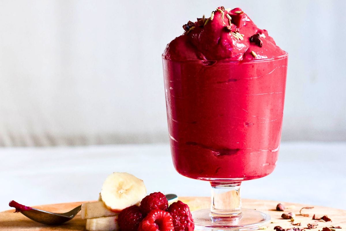 Banana, Raspberries and Beet Nice Cream Delight in a glass above the board.