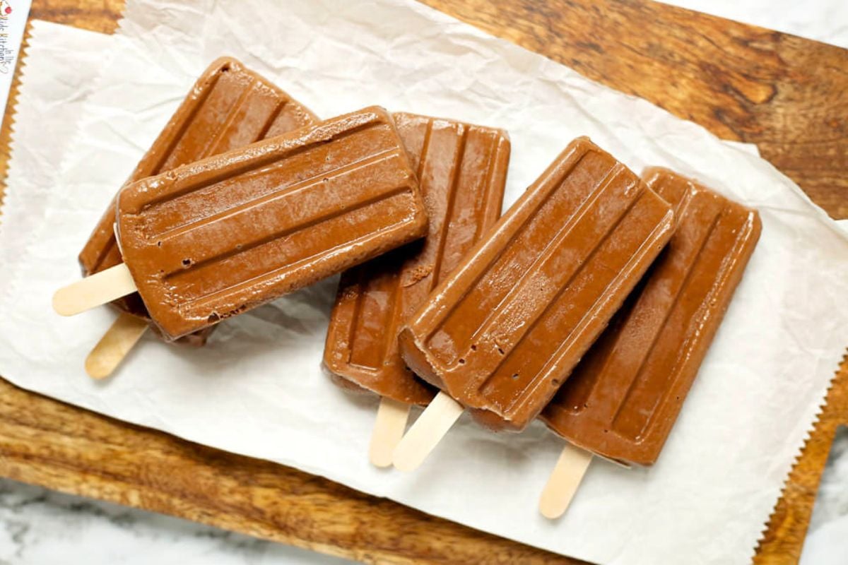 Creamy Avocado Fudgesicles on a wooden board.
