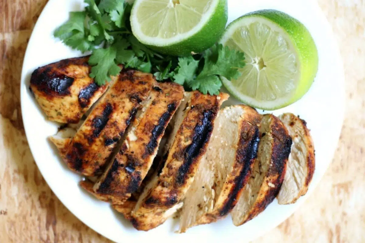 Sliced Grilled Chili Lime Chicken with lime on a plate.