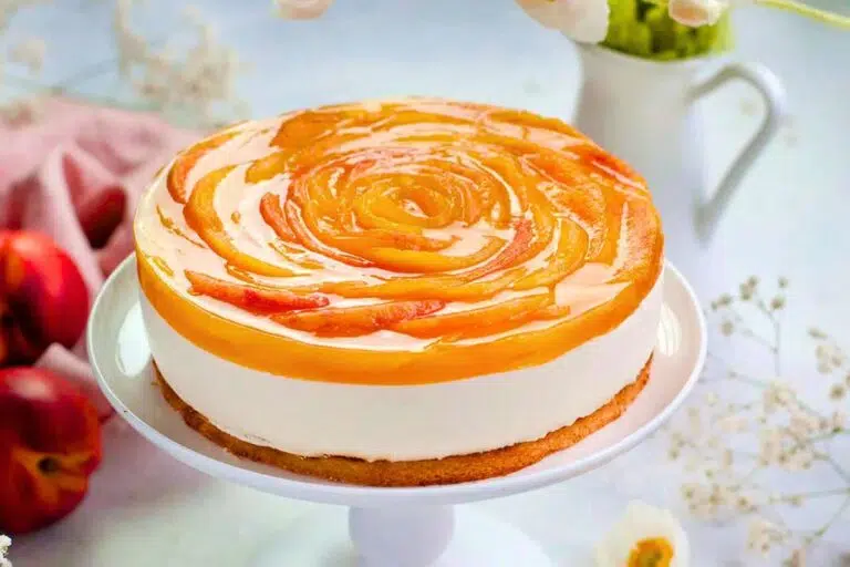Layered Peach Yogurt Cake with Almond Base placed on a cake stand.