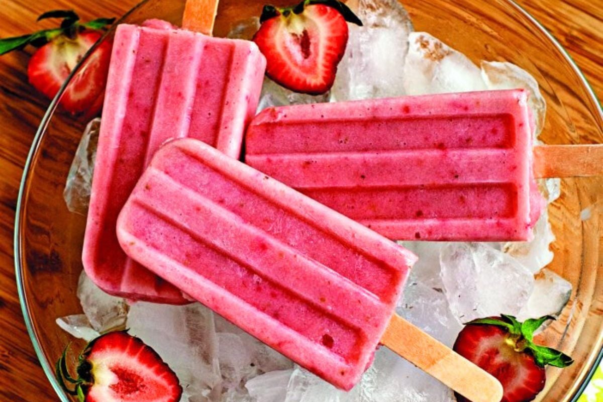 Smoothie Strawberry Banana Popsicles on top of a bowl of ice.