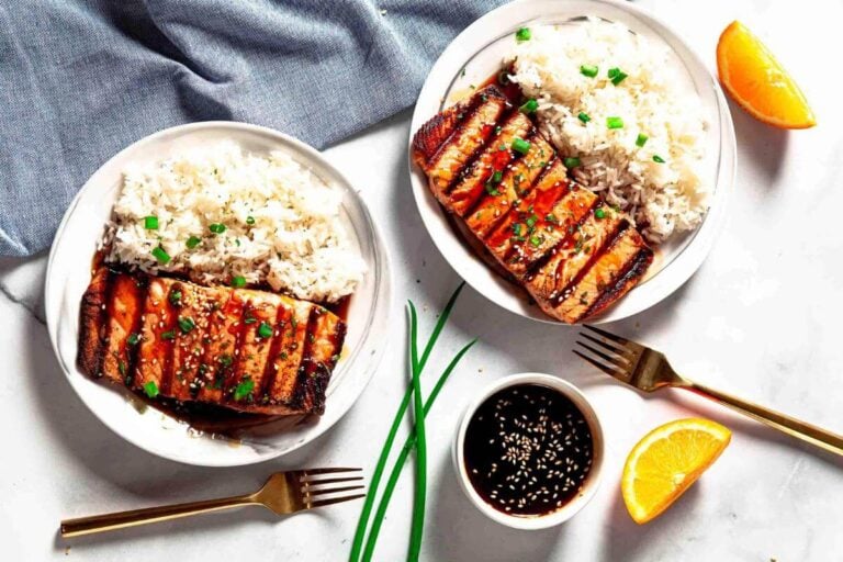 Grillied teriyaki salmon on two plates.