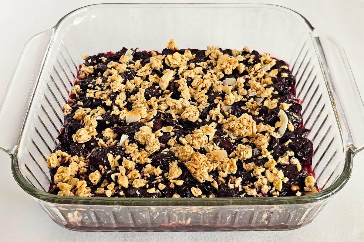 A glass pan full of gluten free cherry crisp.
