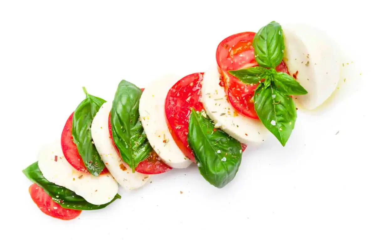 Caprese Salad topped with basil leaves.