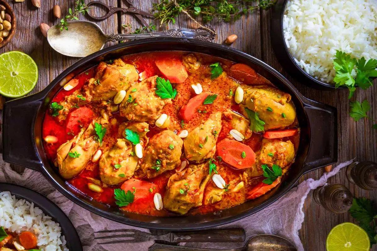 One-Pot West African Spicy Chicken Peanut Stew garnished with nuts.