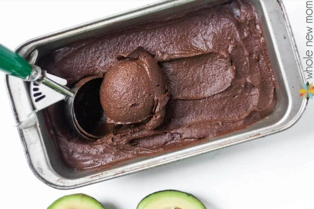 An ice cream scoop scooping up chocolate ice cream.