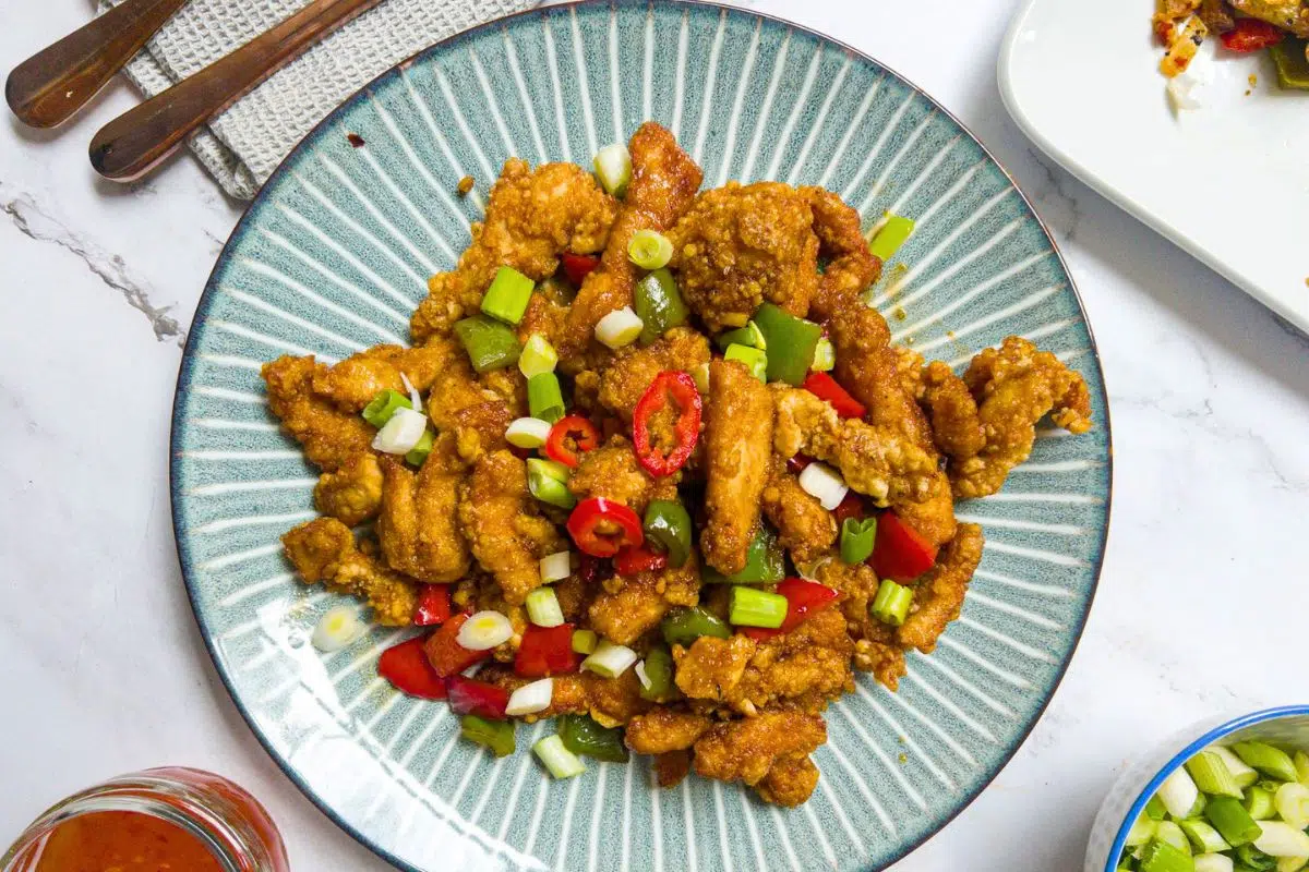 Shredded Chicken With Chilli garnished with chopped chili and spring onions.