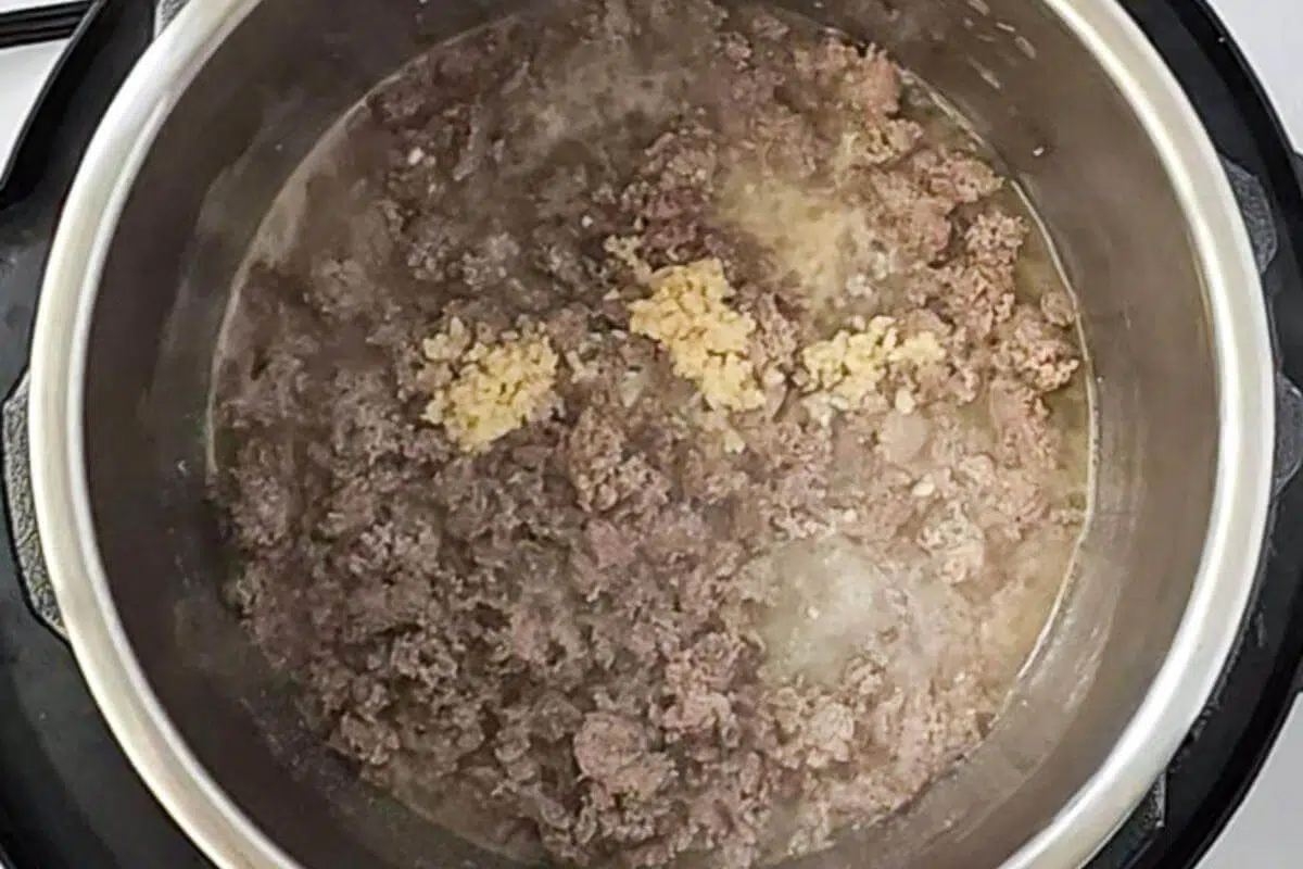 Ground turkey and garlic in a pot.