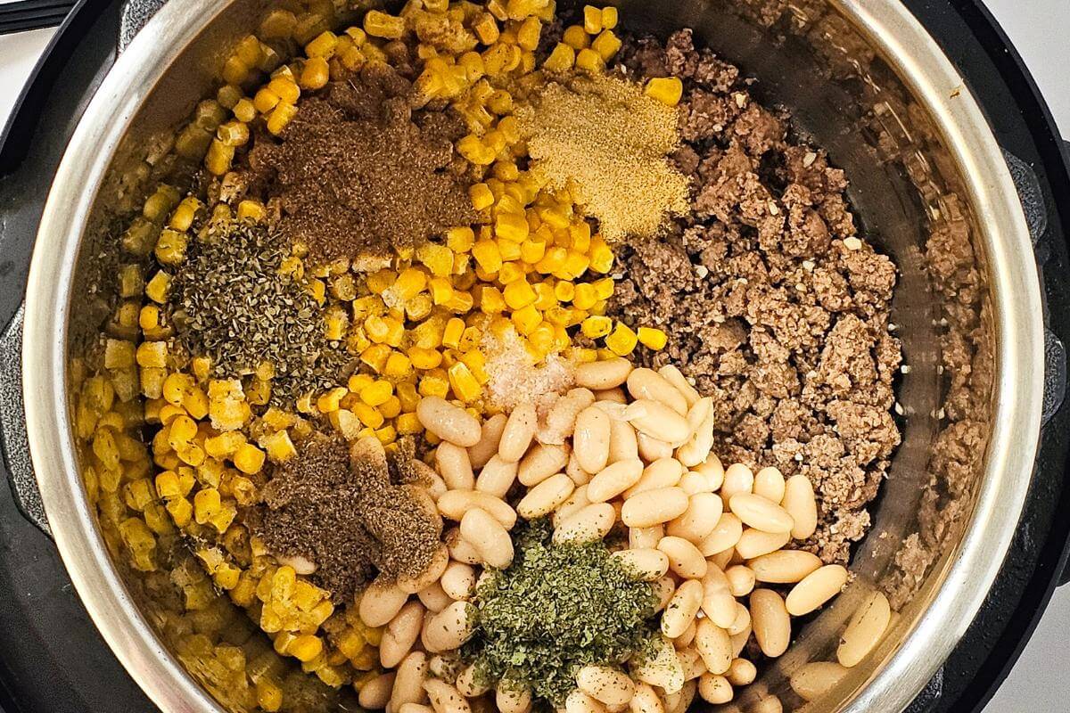 Ingredients for making turkey white bean chili in a pot.