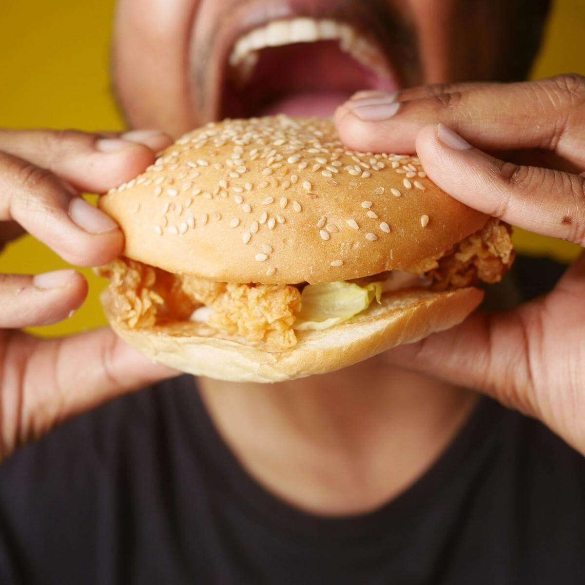 A man eating a chicken sandwich.