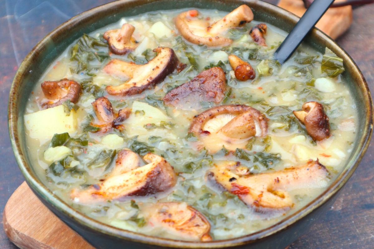 Kale soup with potatoes and shiitake mushrooms in a bowl.