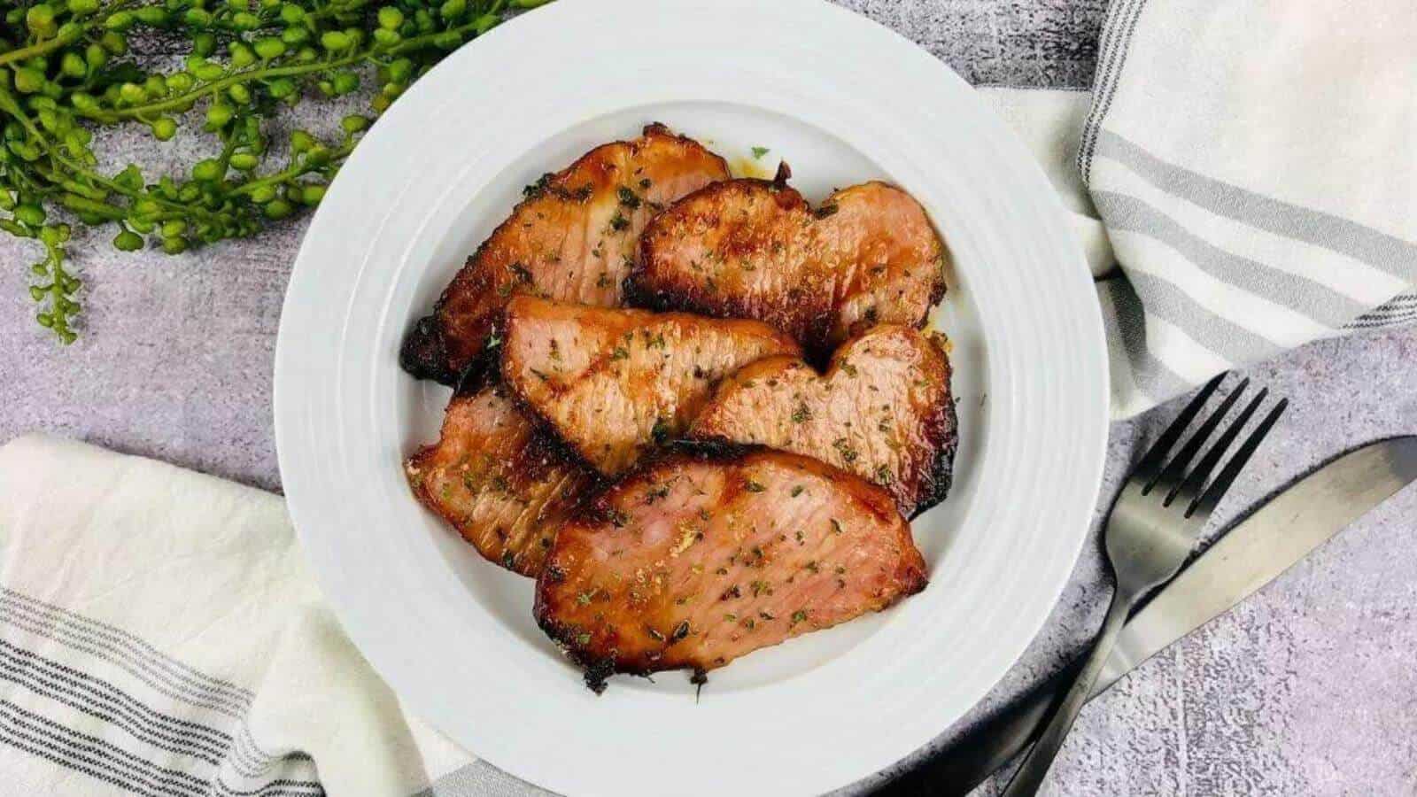 Slices of ham on a white plate.