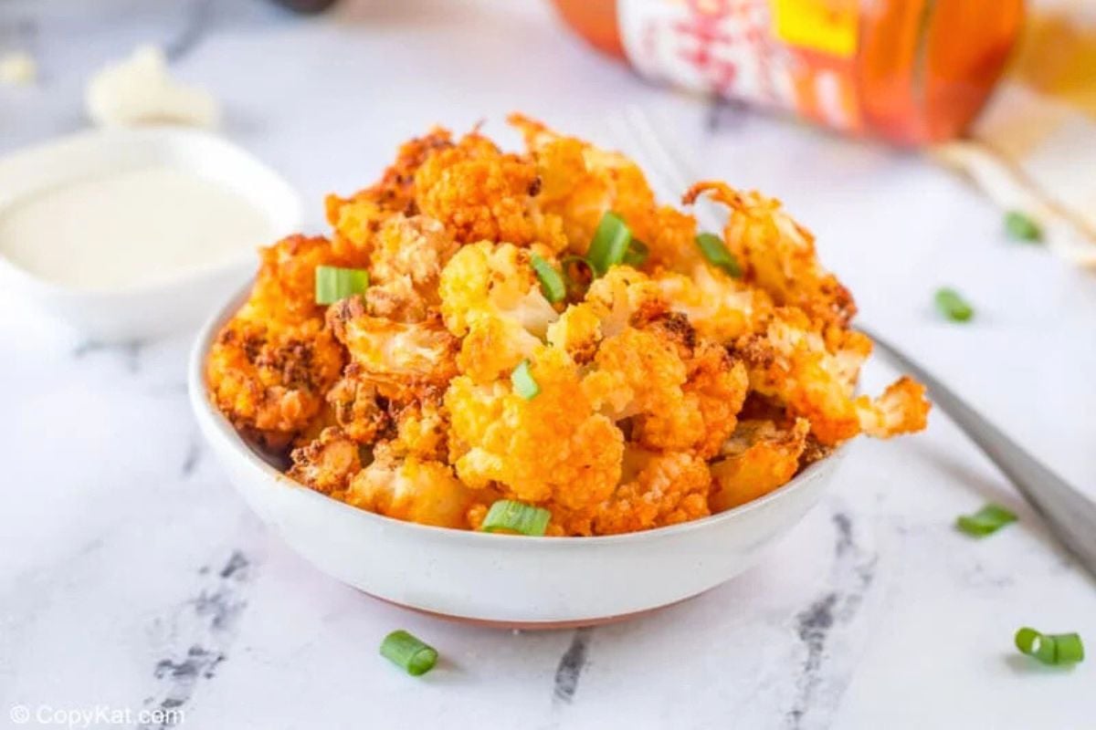 Air Fryer Buffalo Cauliflower garnished with chopped spring onions.