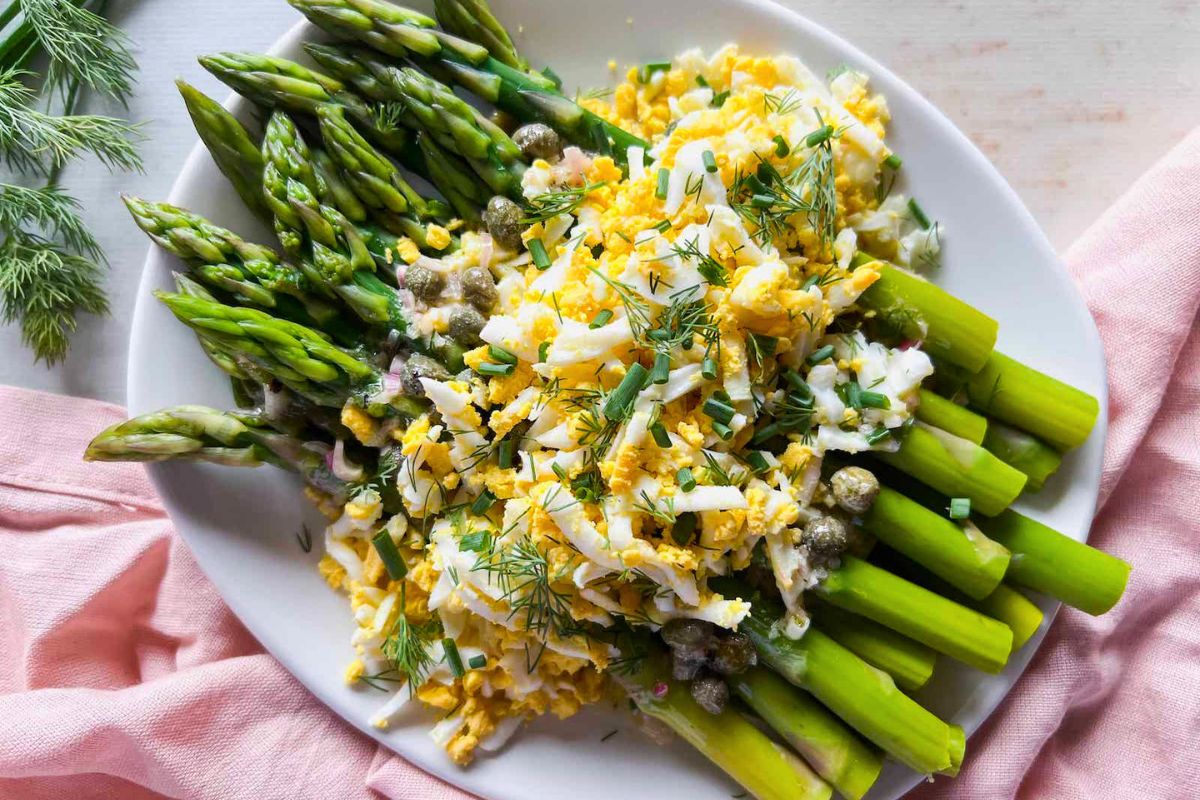 Asparagus Mimosa with Caper Vinaigrette garnished with chopped herbs.