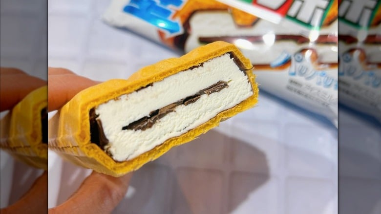 A person holding a Choco Monaka ice cream bar cut in half from 7-Eleven Japan